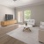 a living room with a wood floor and neutral decor