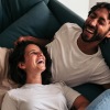 a couple laughing on a couch