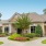 exterior of community clubhouse and leasing office with lush landscaping 